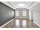 A bright room featuring two windows, hardwood floors, and modern paintwork at 577 Cypher Drive, Suwanee, GA 30024