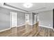 A brightly illuminated bedroom featuring hardwood floors, modern recessed lighting, and neutral walls at 577 Cypher Drive, Suwanee, GA 30024