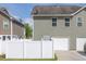 View of the side of the home and a two-car garage, behind a white picket fence at 577 Cypher Drive, Suwanee, GA 30024