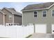 Back of the home showcasing a two-car garage and white picket fencing at 577 Cypher Drive, Suwanee, GA 30024