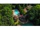 Aerial view of the community pool with lounge chairs, umbrellas, and clubhouse surrounded by mature trees at 63 Lewellen Dr, Marietta, GA 30064