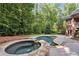 Backyard with swimming pool, a stone-lined hot tub, and mature trees at 63 Lewellen Dr, Marietta, GA 30064