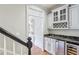 Hallway nook featuring a wine fridge, granite countertops, and built-in cabinets, perfect for entertaining guests at 63 Lewellen Dr, Marietta, GA 30064