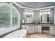 Close up of en-suite bath shows soaking tub with a large window and and vanities at 63 Lewellen Dr, Marietta, GA 30064