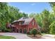 Expansive brick home featuring a three-car garage and a spacious backyard, offering ample space and privacy at 63 Lewellen Dr, Marietta, GA 30064