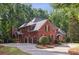 Stately brick home with a three-car garage nestled among mature trees on a well landscaped lot at 63 Lewellen Dr, Marietta, GA 30064