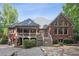 Back exterior featuring a brick home, covered porch, multi-level deck and access to the backyard and pool at 63 Lewellen Dr, Marietta, GA 30064