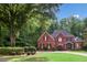 Charming brick home surrounded by lush trees and landscaped grounds, providing a serene and private setting at 63 Lewellen Dr, Marietta, GA 30064