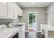 Bright laundry room has washer, dryer, utility sink, counter space, and access to the backyard at 63 Lewellen Dr, Marietta, GA 30064
