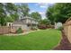 Expansive backyard with a large, well-kept lawn, mature trees, and a charming shed at 9800 Woodfall Dr, Roswell, GA 30076