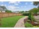 Lush backyard with a manicured lawn, mature landscaping, and charming brick pathway to the deck at 9800 Woodfall Dr, Roswell, GA 30076