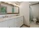 Bathroom boasts a large vanity with dual sinks, a large mirror, tile floors, and glass shower door at 9800 Woodfall Dr, Roswell, GA 30076