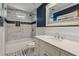 Bright bathroom showcases a vanity with sink, marble countertops, stylish tiles, tub-shower combo, and accent wall at 9800 Woodfall Dr, Roswell, GA 30076