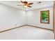 Neutral bedroom features light carpet, one window with green trees outside, and a ceiling fan at 9800 Woodfall Dr, Roswell, GA 30076