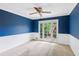 Spacious bedroom with blue walls, white trim, carpet, and a French door leading to the outside at 9800 Woodfall Dr, Roswell, GA 30076