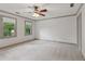Bright bedroom with neutral carpet, natural light from two windows, elegant wall pattern, and a ceiling fan at 9800 Woodfall Dr, Roswell, GA 30076