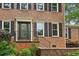 Close-up of front entrance with a detailed door, brick facade, and well-maintained landscaping at 9800 Woodfall Dr, Roswell, GA 30076