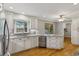 Bright kitchen features stainless steel appliances, tile backsplash, granite countertops, hardwood floors and white cabinets at 9800 Woodfall Dr, Roswell, GA 30076