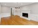 Cozy living room featuring hardwood floors, a fireplace, and classic white wainscoting at 9800 Woodfall Dr, Roswell, GA 30076