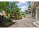 Back patio featuring stone pavers, mature landscaping, and access to a screened-in porch at 9800 Woodfall Dr, Roswell, GA 30076
