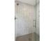 Modern shower features a glass door, stylish herringbone patterned tile, and sleek fixtures at 9800 Woodfall Dr, Roswell, GA 30076