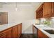 Home bar with white countertops, stainless sink, under cabinet lighting and rich wood cabinets and wine storage at 1211 Thornwell Dr, Brookhaven, GA 30319