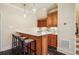 Wet bar with modern pendant lighting, white countertops, rich wood cabinets, wine storage, and counter seating at 1211 Thornwell Dr, Brookhaven, GA 30319
