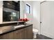 Elegant half bathroom featuring a sleek vanity with black countertop and stylish black tile accent wall at 3293 Lenox Ne Pl, Atlanta, GA 30324