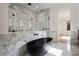 Modern bathroom featuring a black soaking tub, glass enclosed shower, and marble-look tile throughout at 3293 Lenox Ne Pl, Atlanta, GA 30324