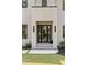 Elegant modern home entrance with double doors, decorative lighting, and lush landscaping at 3293 Lenox Ne Pl, Atlanta, GA 30324