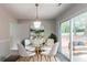 Charming dining area with a glass table, white chairs, and sliding doors to the outdoors at 3851 Natalie Way, Ellenwood, GA 30294