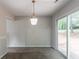 Bright dining area featuring neutral paint, sliding glass doors to the back, and modern light fixture at 3851 Natalie Way, Ellenwood, GA 30294