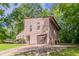 Home featuring a garage and a private driveway, surrounded by lush greenery and mature trees at 3851 Natalie Way, Ellenwood, GA 30294