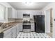 Functional kitchen with stainless steel appliances, neutral cabinets and unique tile flooring at 3851 Natalie Way, Ellenwood, GA 30294