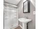 Bathroom featuring tiled floors, pedestal sink, framed mirror, and walk in shower with glass door at 644 Albert Nw St, Atlanta, GA 30318