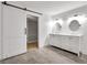 Bathroom features a double sink vanity, tile floors, and a sliding barn door to the closet at 644 Albert Nw St, Atlanta, GA 30318