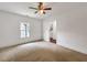 A bright bedroom with neutral carpet, featuring a ceiling fan and an open doorway to an adjacent room at 644 Albert Nw St, Atlanta, GA 30318