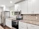 Bright kitchen featuring white cabinets, granite countertops, stainless appliances, and subway tile backsplash at 644 Albert Nw St, Atlanta, GA 30318