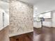 Open-concept design with brick wall and kitchen featuring white cabinets and stainless steel appliances at 644 Albert Nw St, Atlanta, GA 30318