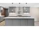 Close up of the grey kitchen with large center island, stainless appliances and pendant lights at 1120 Taliwa Ne Trl, Marietta, GA 30068