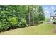 Spacious backyard featuring a lush green lawn and mature trees providing ample shade and privacy at 1980 Marcia Overlook Dr, Cumming, GA 30041