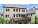 Two-story backyard view of a home featuring a deck, patio, and an outdoor dining area at 1980 Marcia Overlook Dr, Cumming, GA 30041