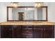 Bathroom vanity featuring double sinks, granite countertops, wood cabinets, and framed mirror at 1980 Marcia Overlook Dr, Cumming, GA 30041