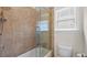 Bathroom featuring shower with glass doors, tile surround, and a toilet at 1980 Marcia Overlook Dr, Cumming, GA 30041