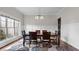 Bright dining room featuring a large window, modern chandelier, and hardwood floors at 1980 Marcia Overlook Dr, Cumming, GA 30041