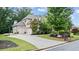 Side view of a brick home featuring an attached garage, long driveway, and manicured lawn at 1980 Marcia Overlook Dr, Cumming, GA 30041
