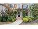 Covered front porch and entrance with stone accents surrounded by landscaped garden at 1980 Marcia Overlook Dr, Cumming, GA 30041