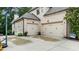 Two-car garage with automatic doors, exterior lighting, and landscaping at 1980 Marcia Overlook Dr, Cumming, GA 30041