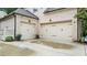 A two car garage featuring paneled garage doors, exterior lights and a clean driveway at 1980 Marcia Overlook Dr, Cumming, GA 30041