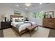 Beautifully furnished bedroom with a window view, a wooden bed frame, and an upholstered leather bench at 280 E Valley Dr, Marietta, GA 30068